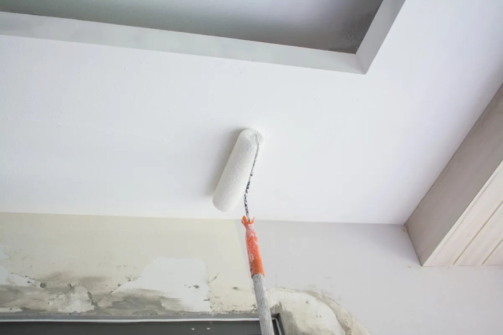 peinture intérieure sur un plafond, application réalisée avec un rouleau à peinture pour une finition lisse